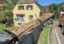 Stmk: Zugmaschine verliert Sattelauflieger mit Baumstämmen → Auflieger landet auf Gartenhaus