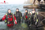 2 Tauchlehrer mit je einem Kursteilnehmen vor dem Abtauchen